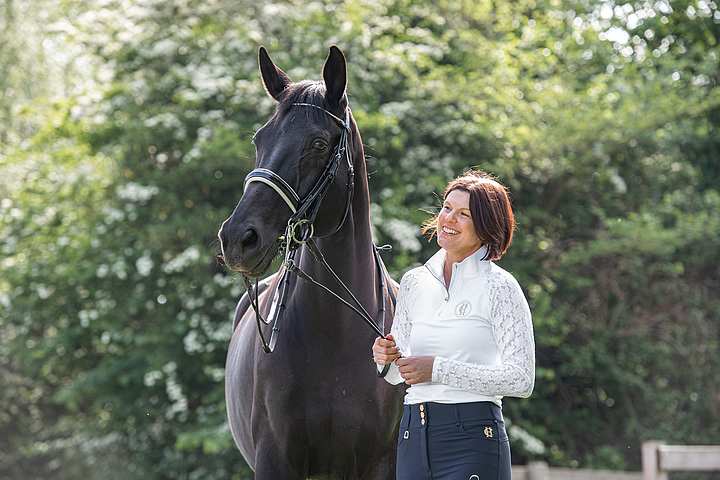 Woman walking a horse in woods